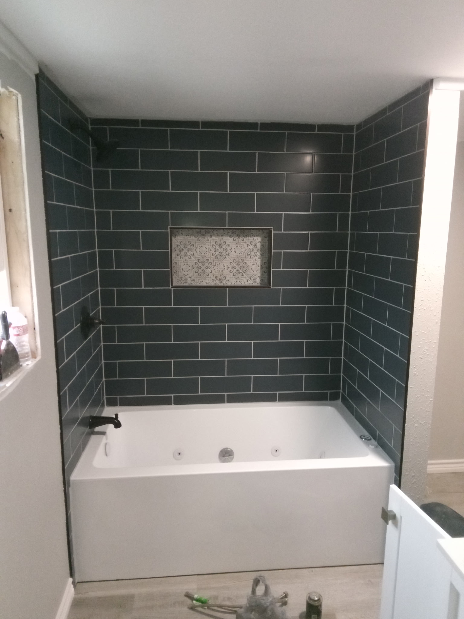Blue tile bathtub surround with decorative recessed niche