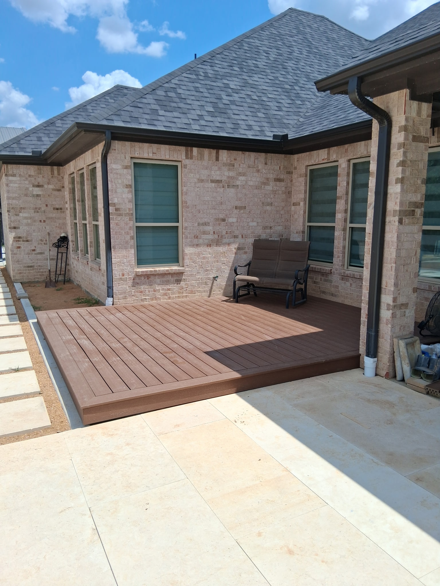 Composite platform deck adjoining a brick home