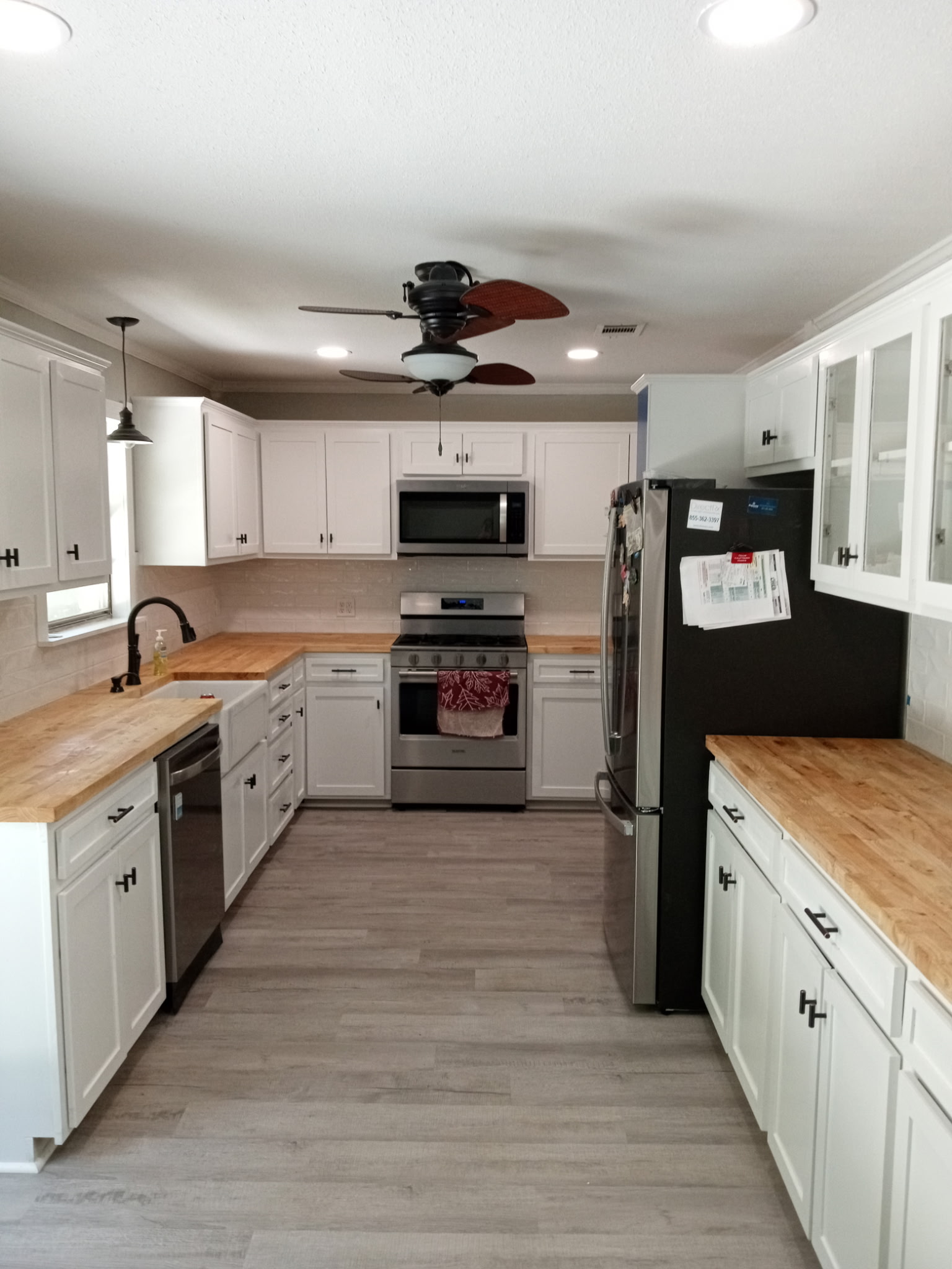 Remodeled kitchen with white cabinets and wood countertops