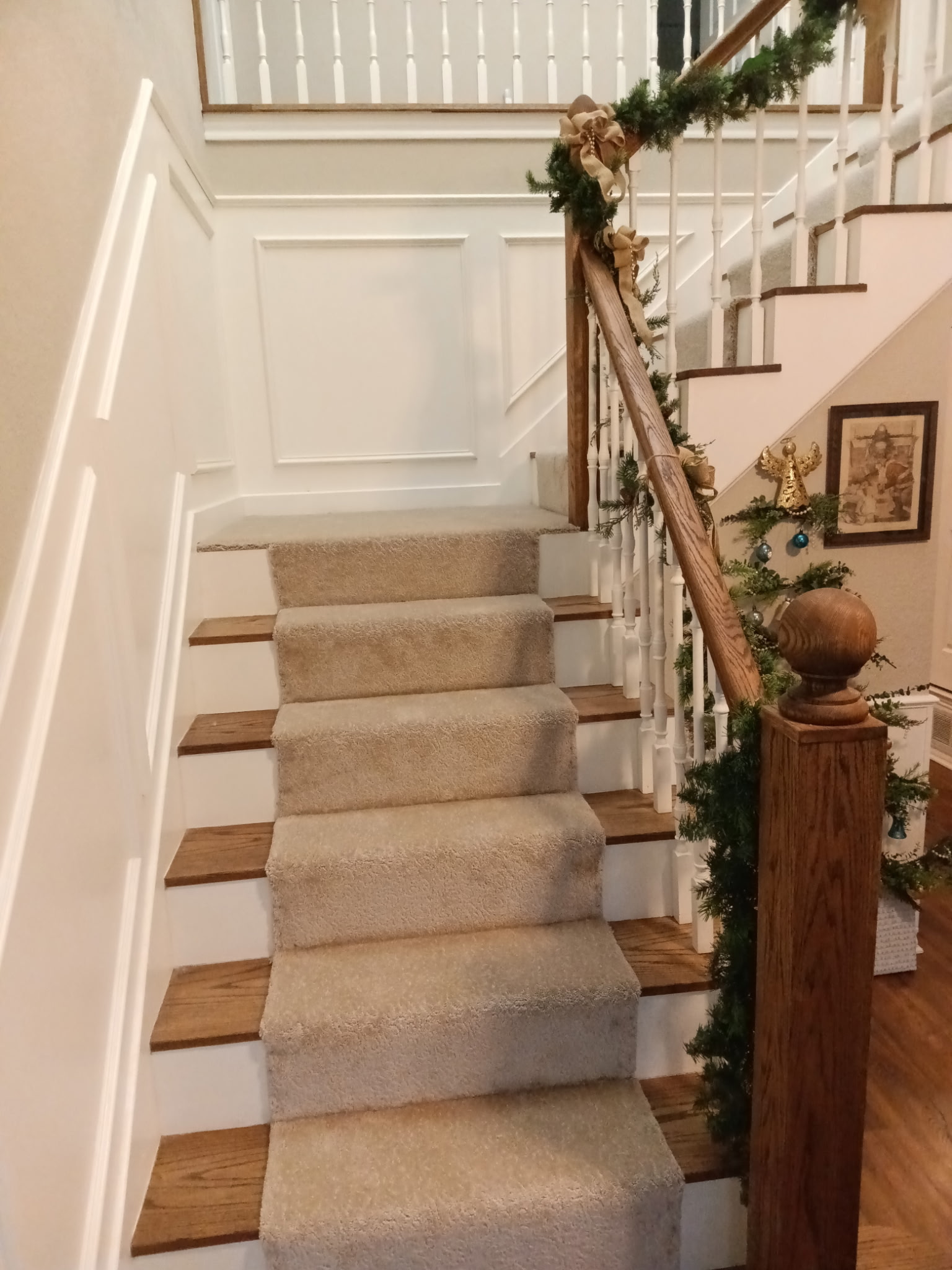 Renovated staircase with carpet runner and decorative wall paneling
