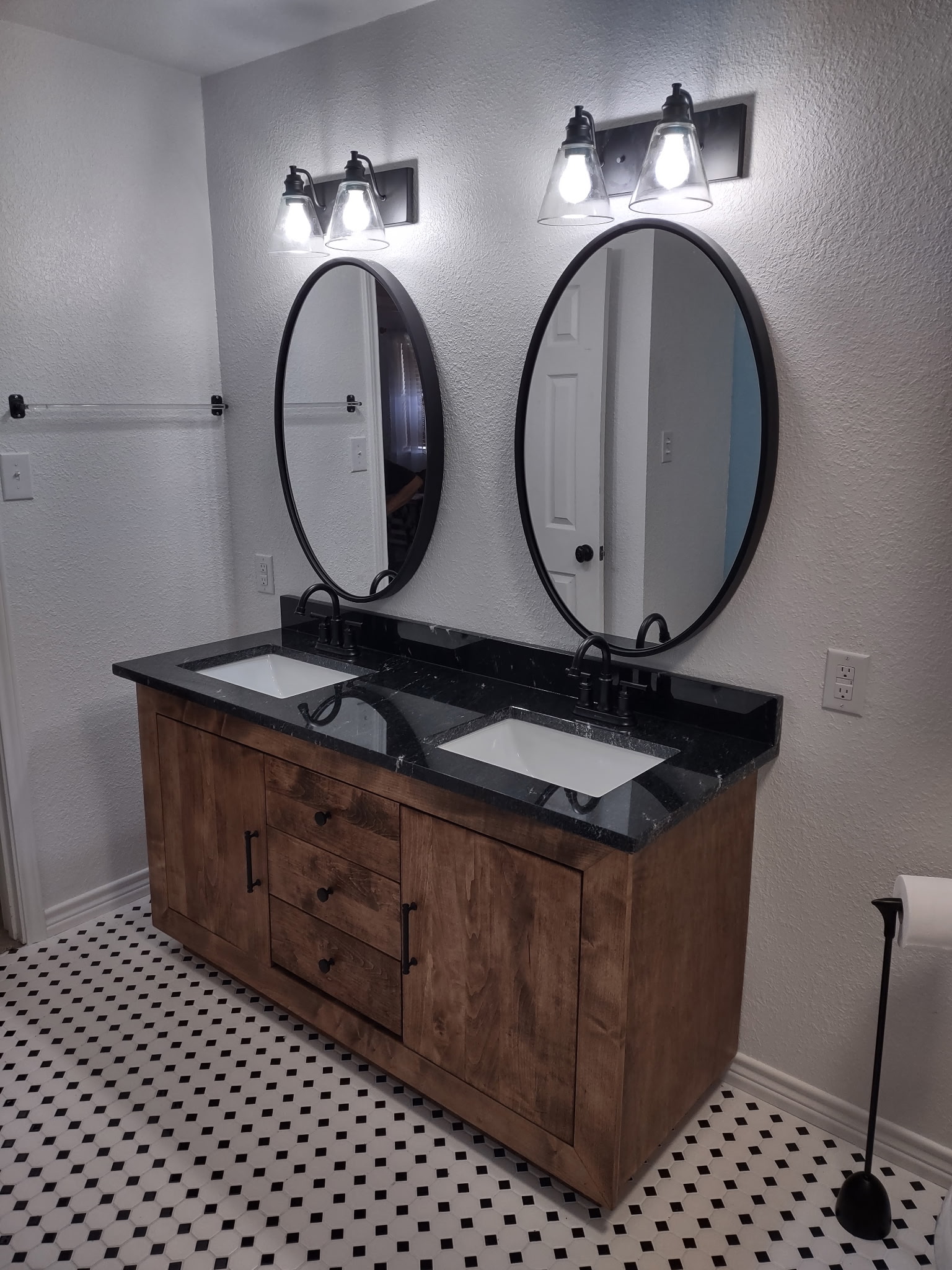 Wood double vanity and black-and-white bathroom flooring